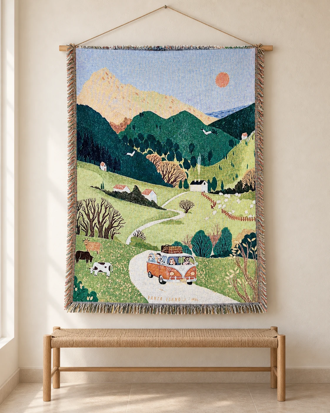 An orange camper van on a winding road through green hills on a hanging tapestry
