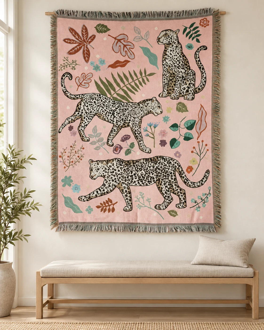 Three black-spotted cream leopards on pink, one seated upper right and two walking below, scattered leaves and flowers