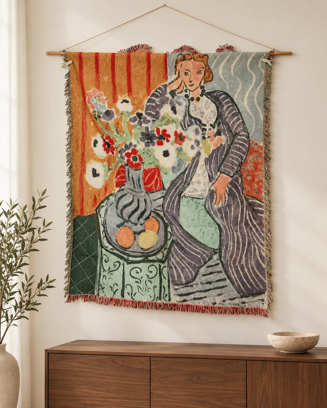 Seated woman on right in gray-purple striped dress, leaning head on hand, anemone bouquet left, fruit plate bottom left, orange striped background upper left