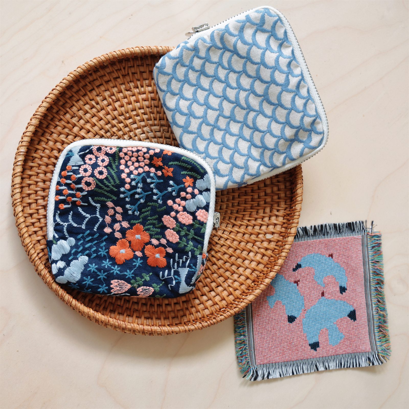 Three small patterned fabric pieces arranged on a woven tray