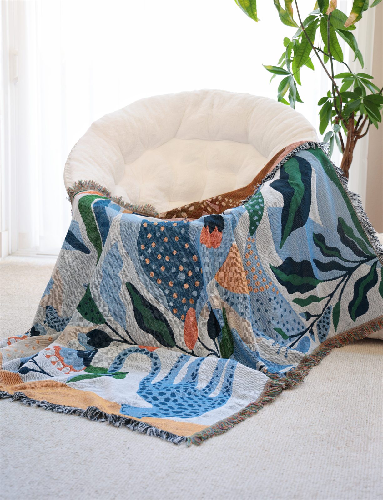 Blue patterned textile arranged as a soft pet bed beside a window and plant